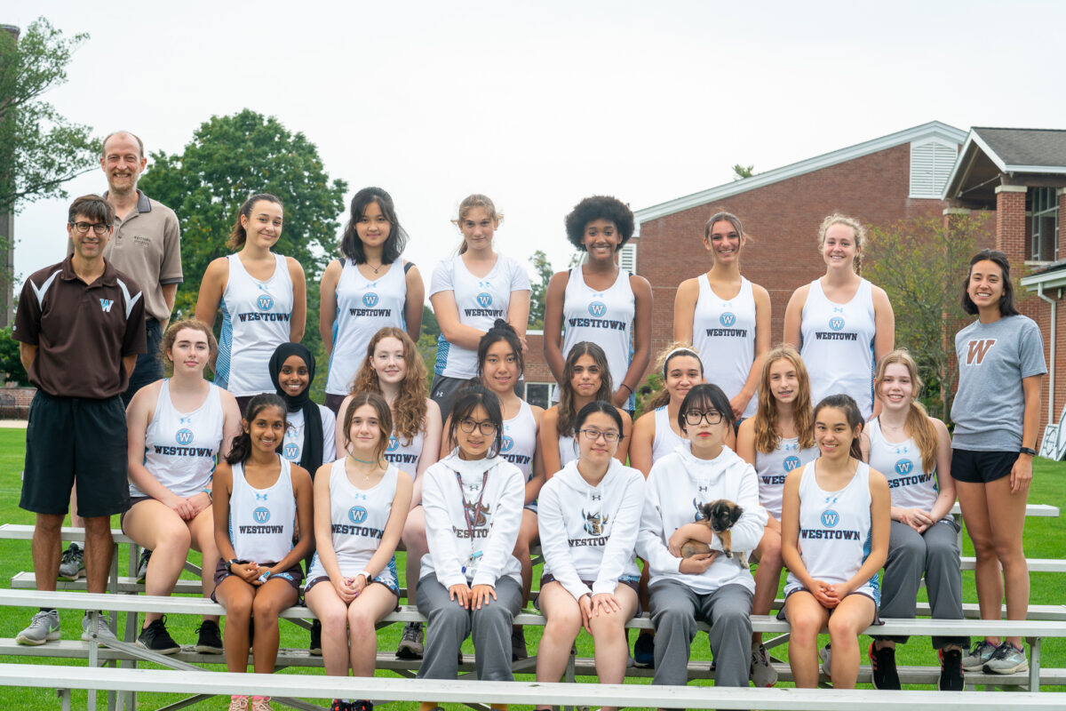 Girls Cross Country Team posing on bleachers