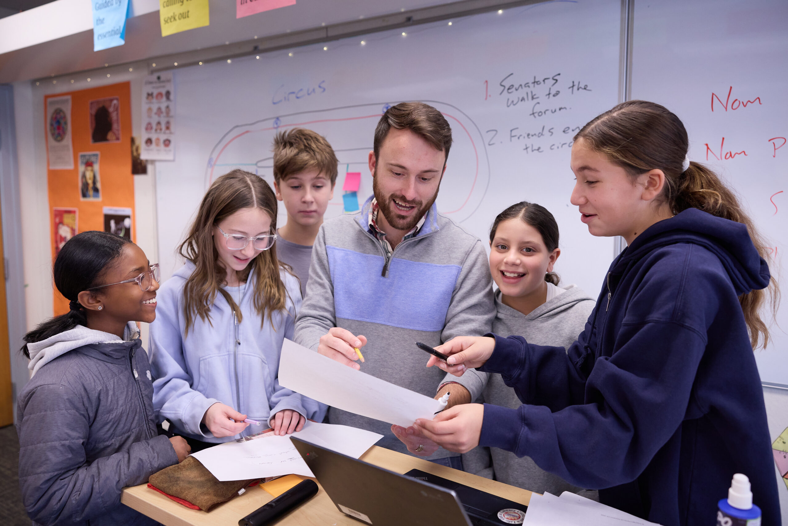 students gathered around teacher