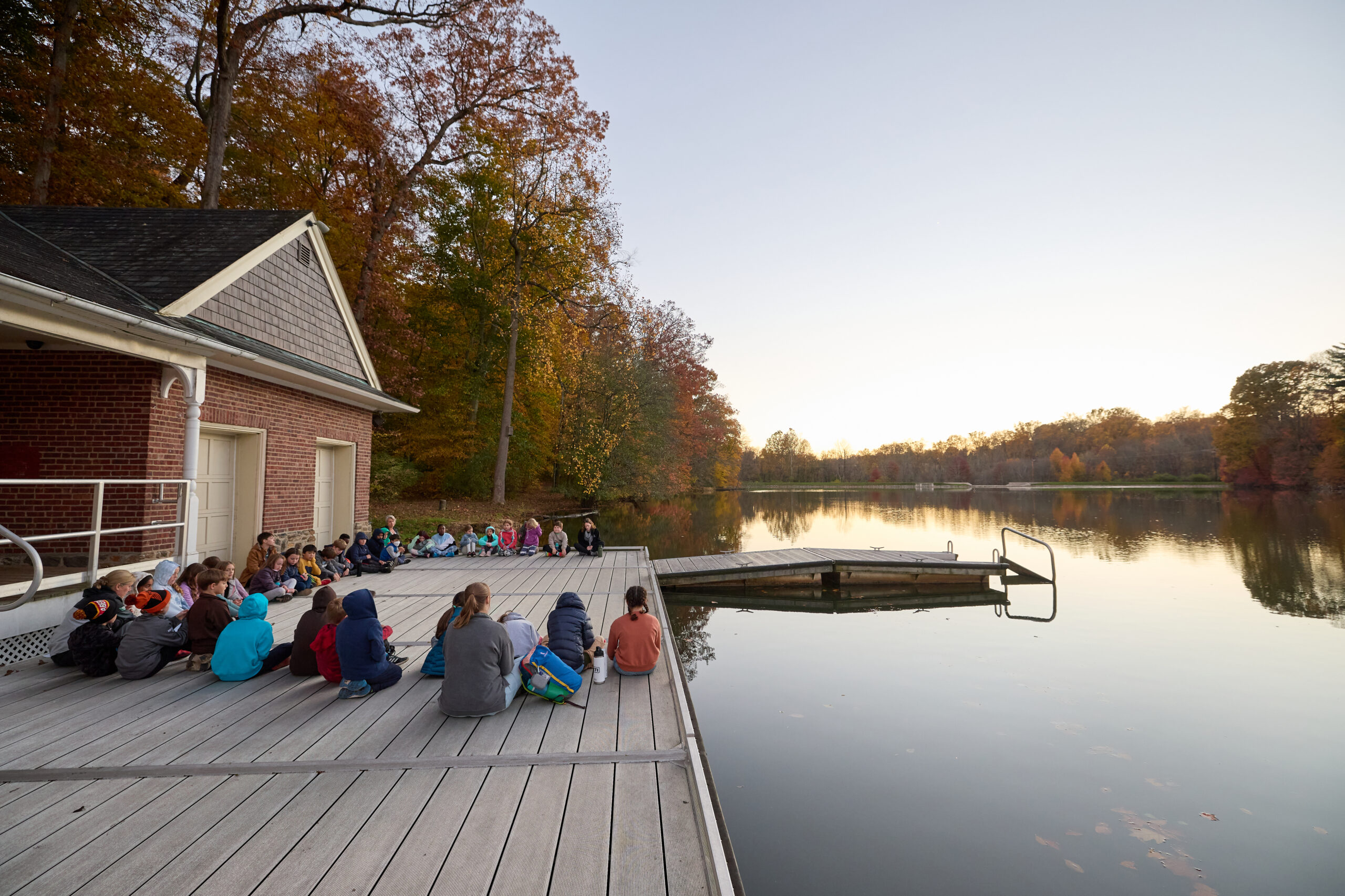 lower school students sitting in contemplation at the lake